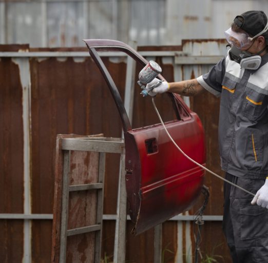 man-spraying-powder-paint-car-door-medium-shot
