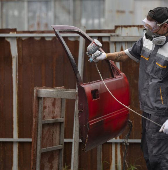 man-spraying-powder-paint-car-door-medium-shot